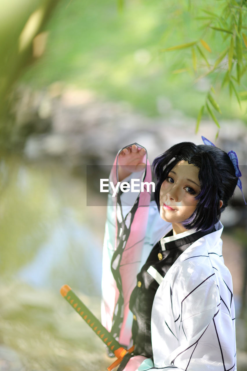 portrait of smiling young woman standing outdoors