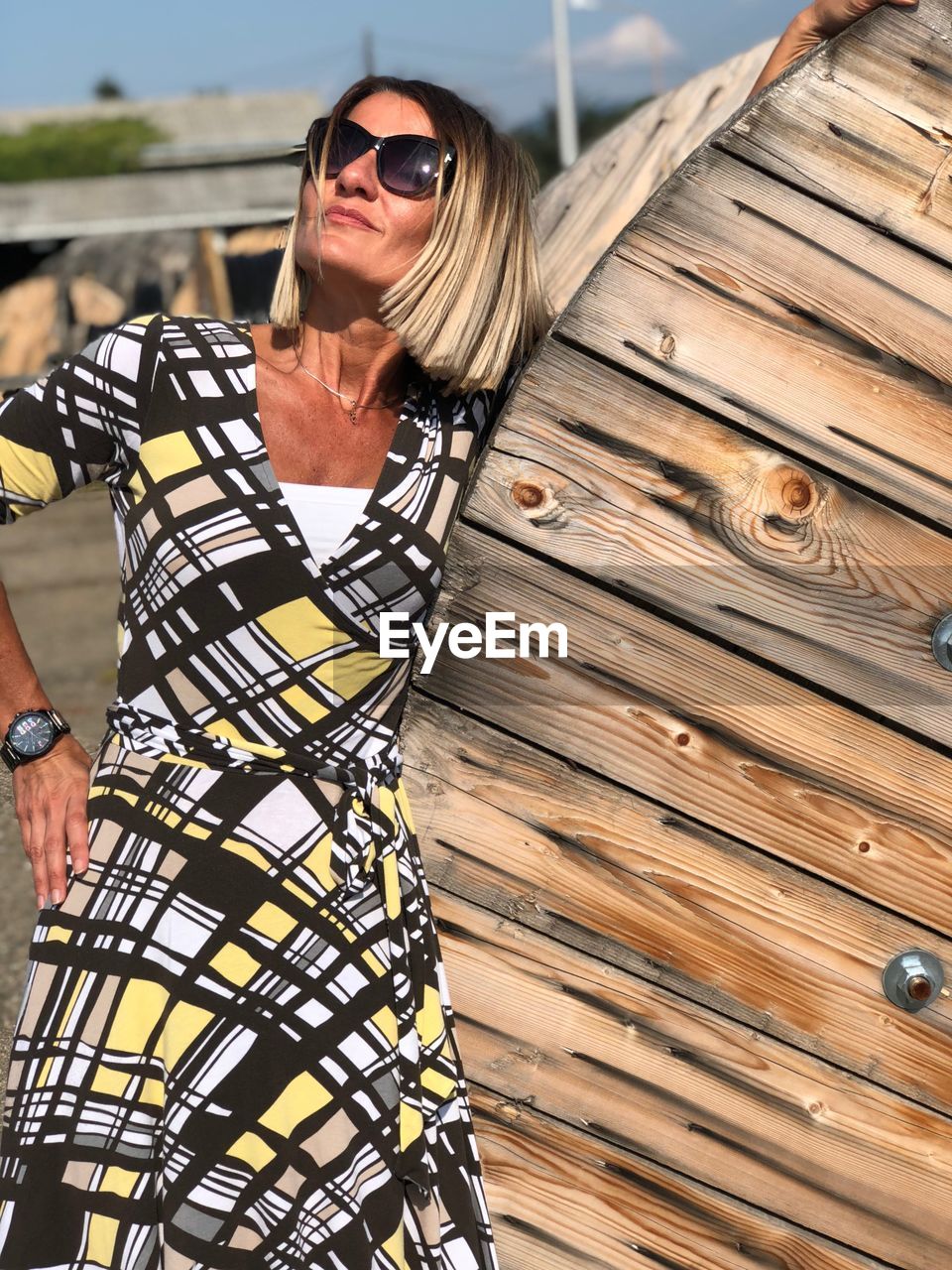 Smiling woman standing by wooden structure