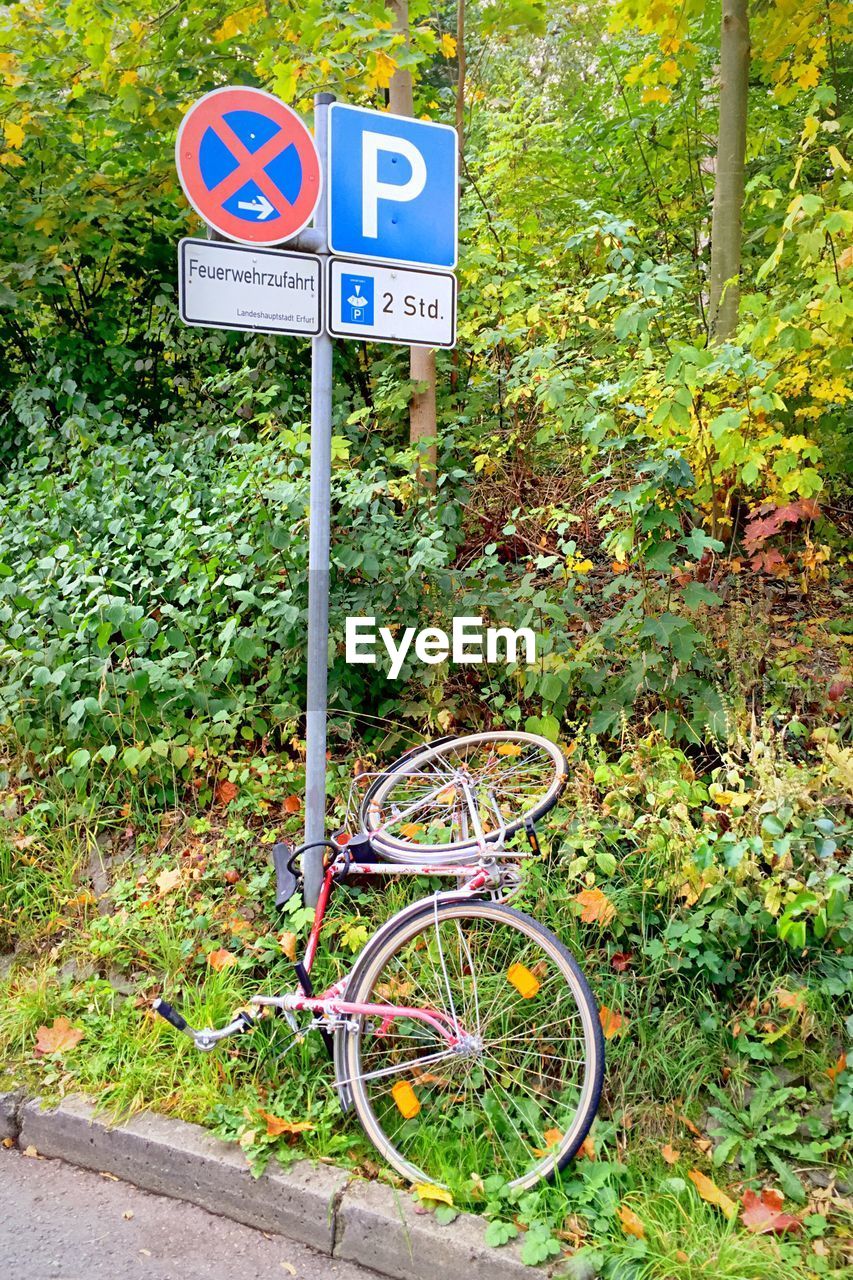 High angle view of bicycle on plants by road sign
