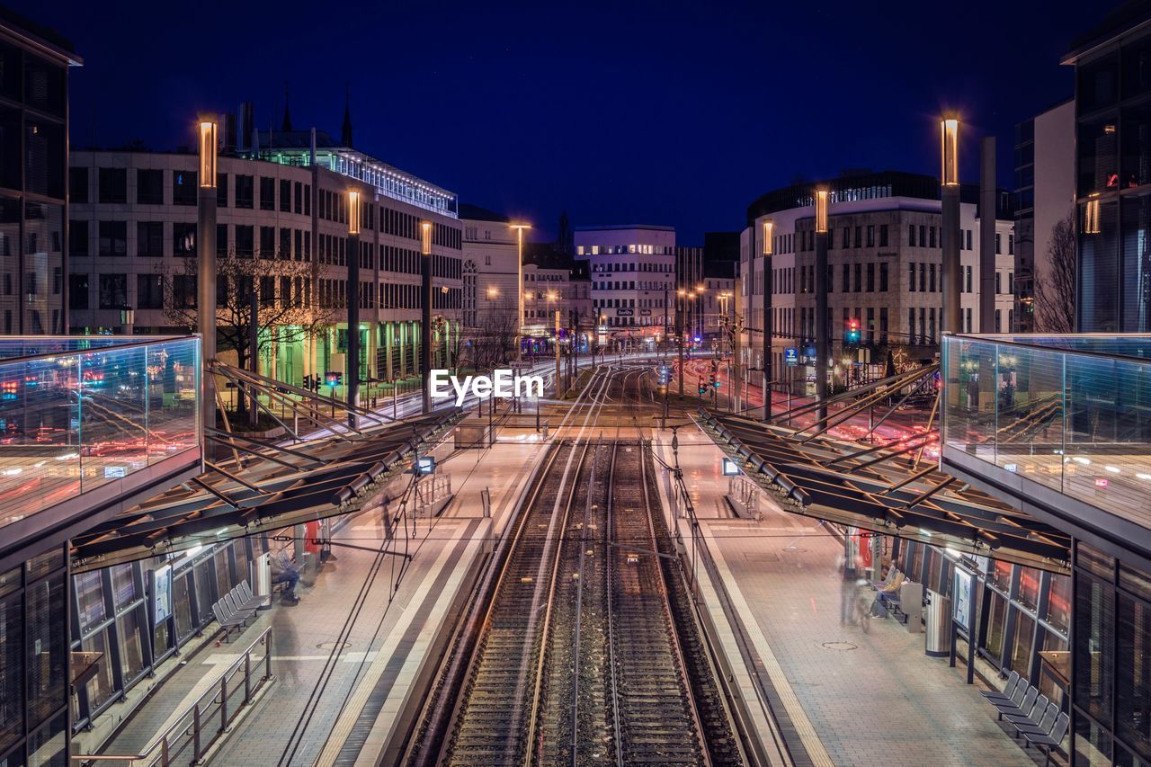 HIGH ANGLE VIEW OF RAILROAD TRACKS AMIDST BUILDINGS IN CITY