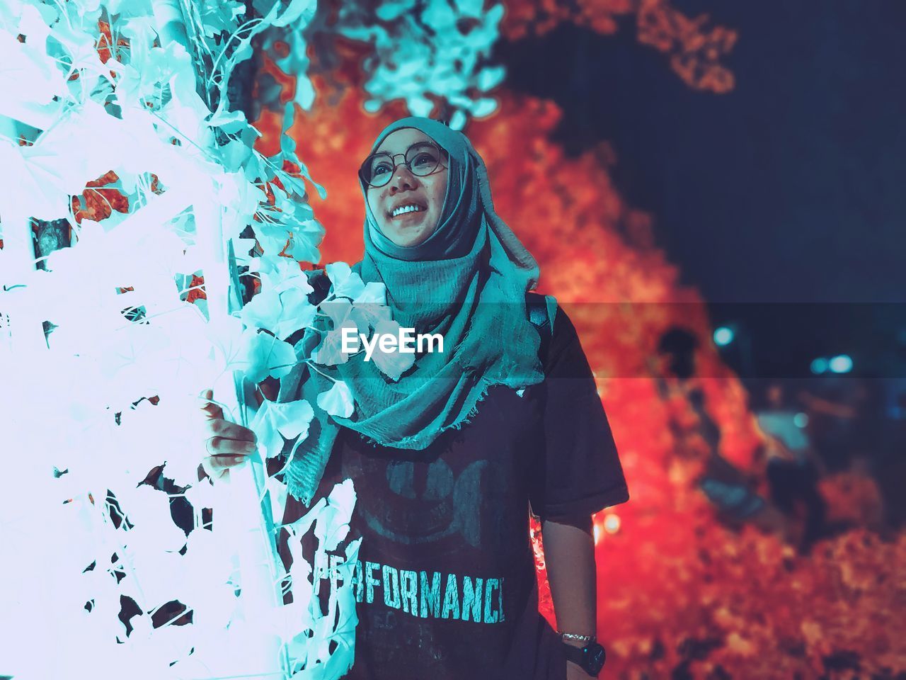 FULL LENGTH OF A WOMAN STANDING AGAINST ILLUMINATED STAR FIELD