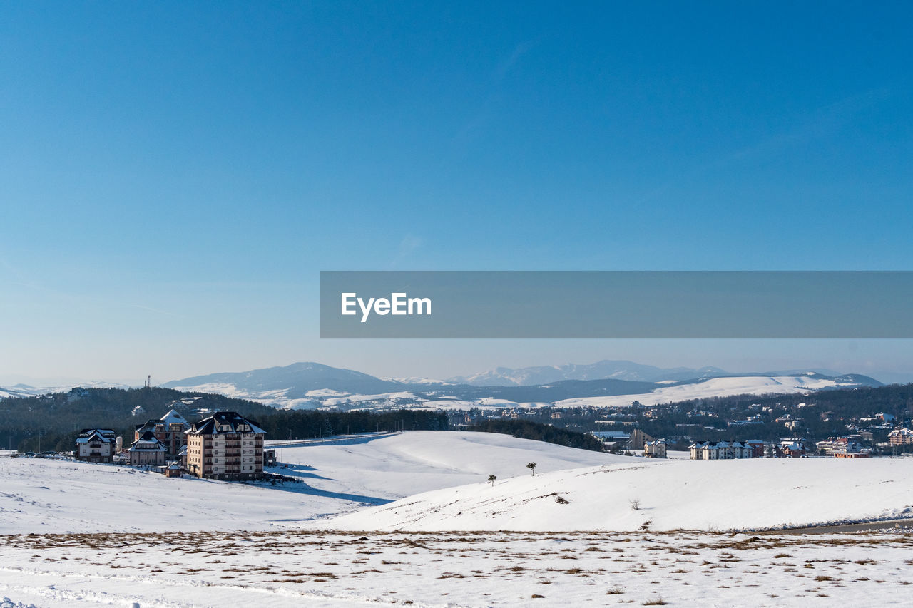 Scenic view of snowcapped mountains against clear blue sky