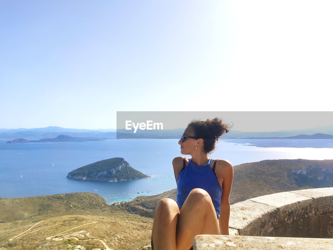 Young woman looking at sea against sky after trekking