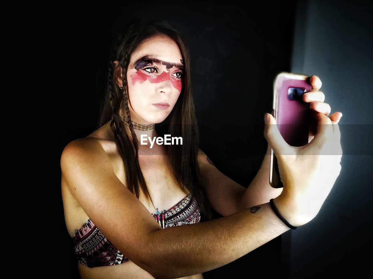 Young woman with face paint taking selfie