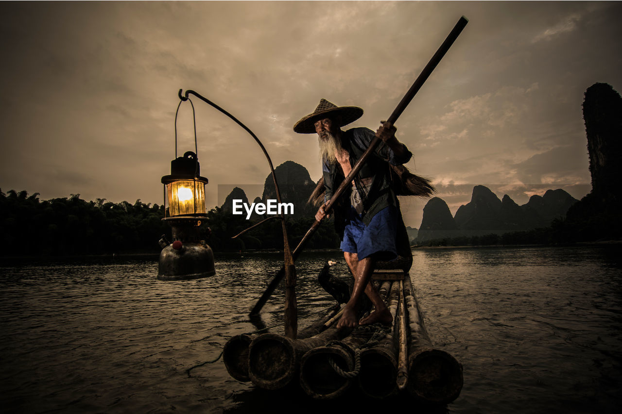 Senior chinese fisherman at sunset