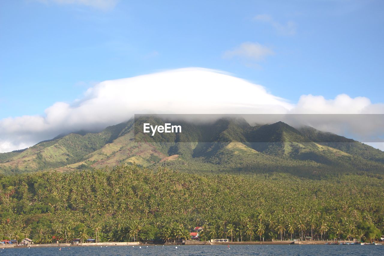 Scenic view of lake by mountains against sky