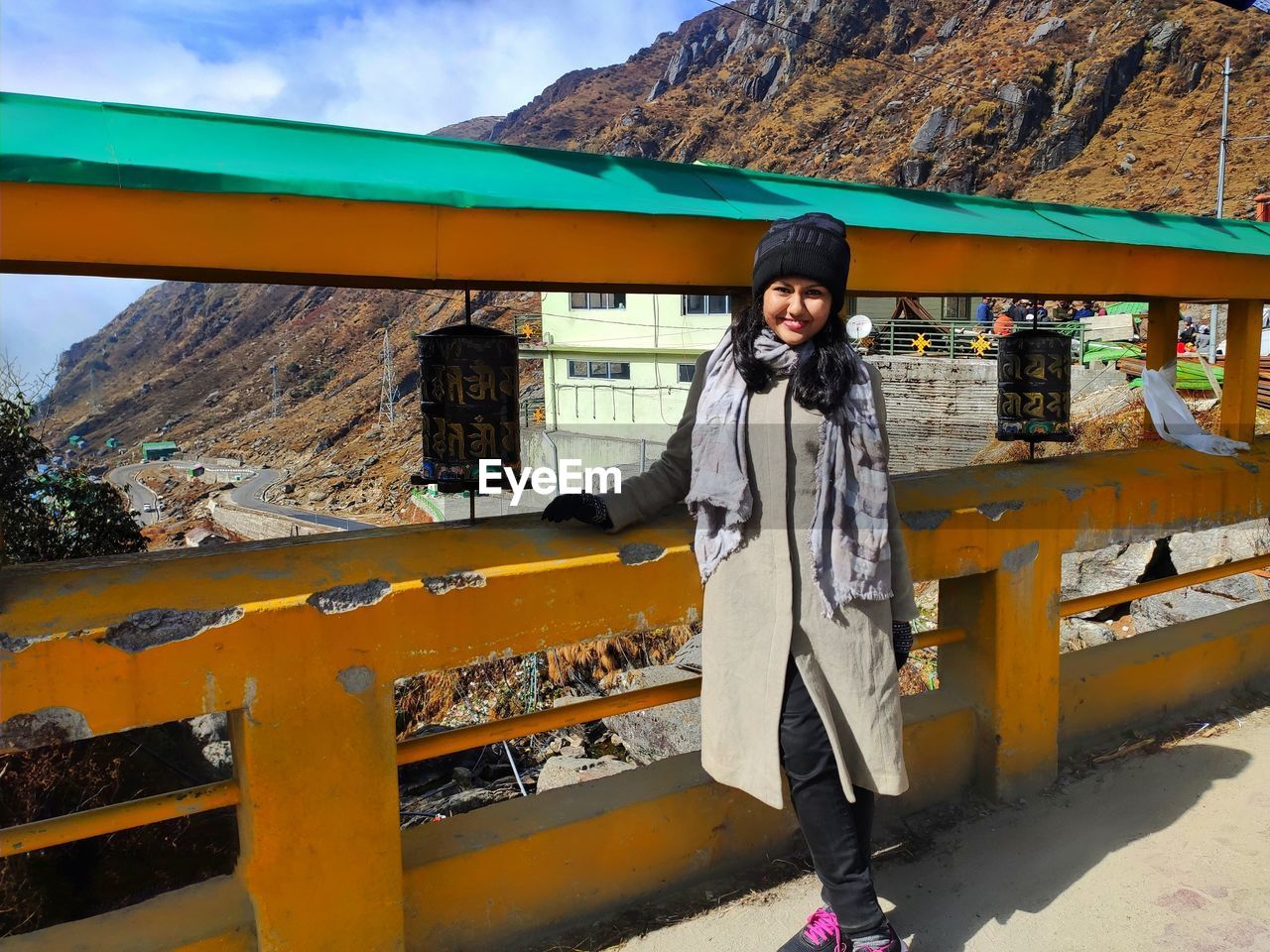 Portrait of young woman standing against mountain