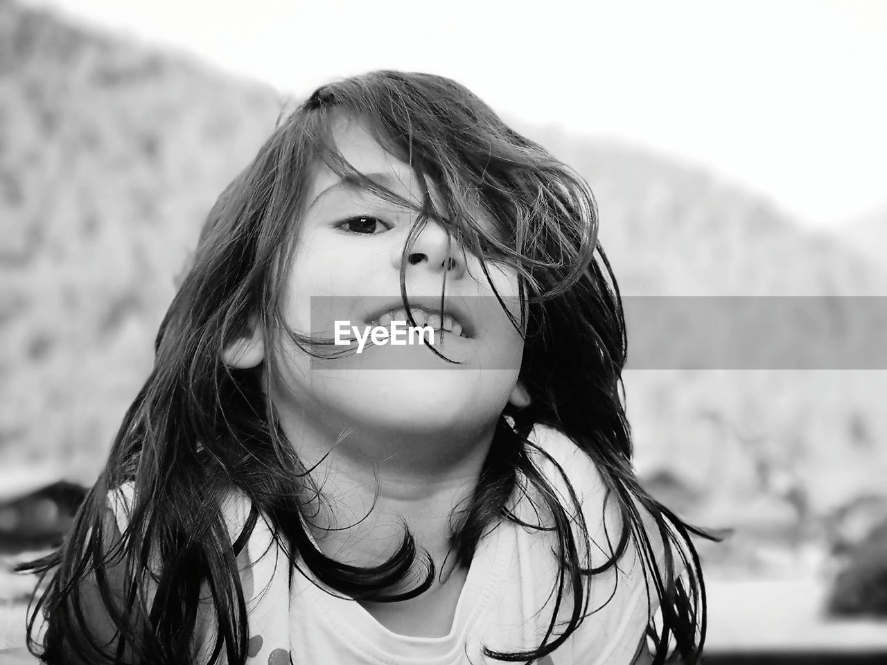 Low angle portrait of smiling girl against sky