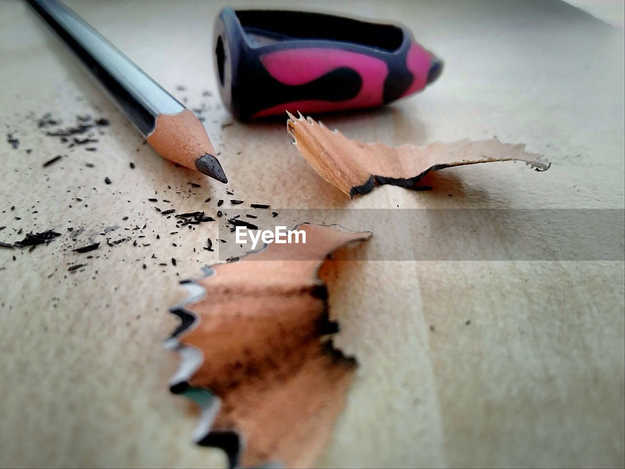 Pencil and sharpener with shavings on table