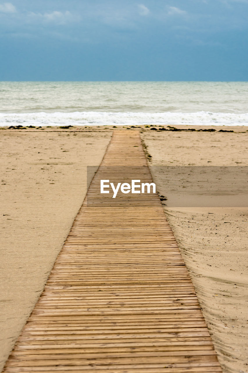 Boardwalk on beach against sky