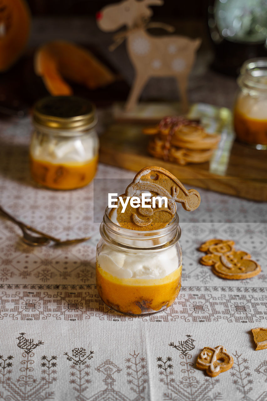 Homemade pumpkin and cream mousse in jar with ginger cookie 