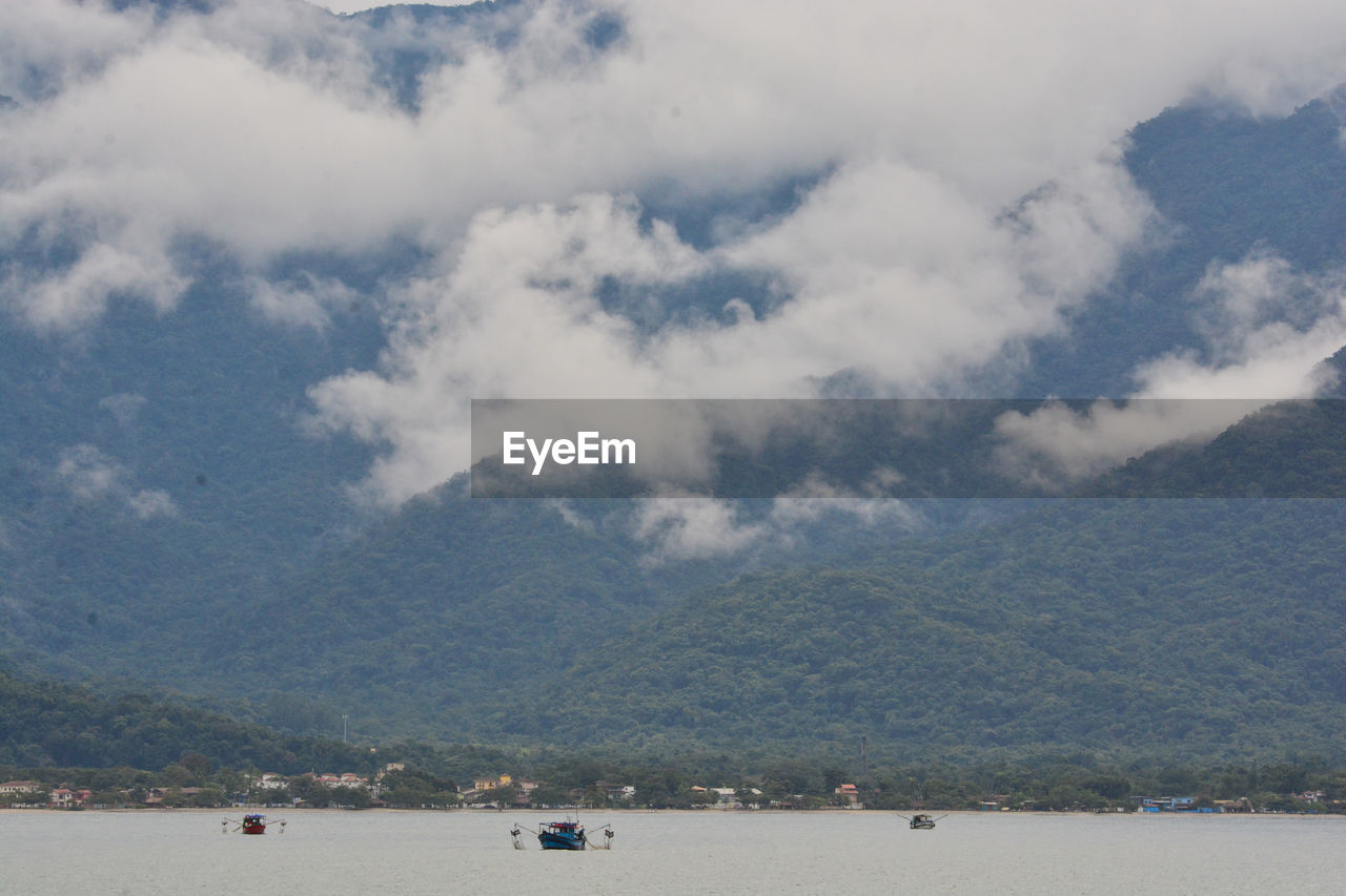 Scenic view of sea and mountains against sky