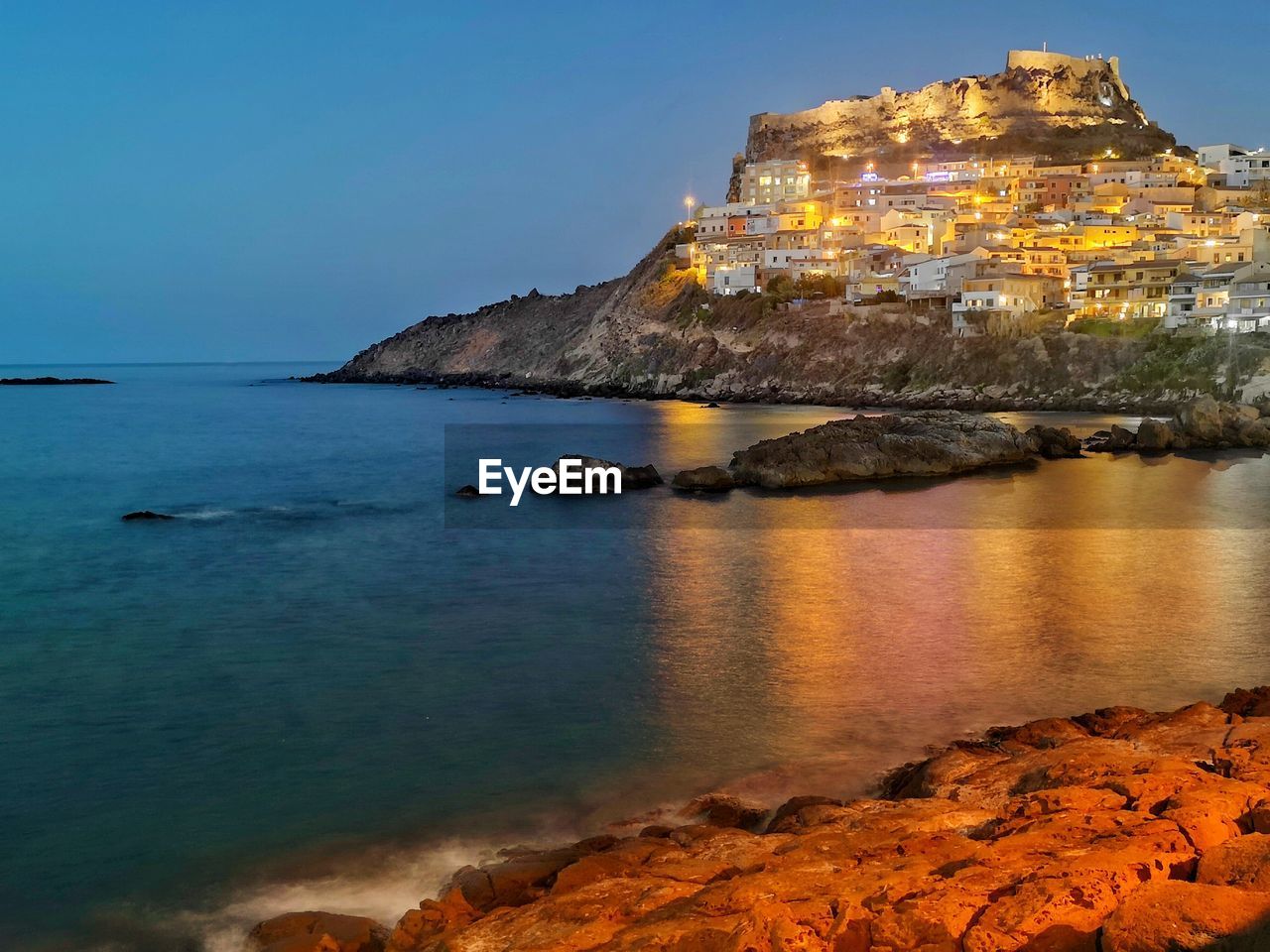water, sea, land, sky, coast, cliff, beach, architecture, travel destinations, rock, nature, ocean, scenics - nature, terrain, shore, building exterior, travel, beauty in nature, dusk, horizon, bay, built structure, building, coastline, reflection, no people, body of water, tourism, history, outdoors, blue, tranquility, clear sky, the past, landscape, evening, rock formation, holiday, castle, trip, tranquil scene, sunset, environment, tower, vacation, island, city, night, seascape, idyllic, fort