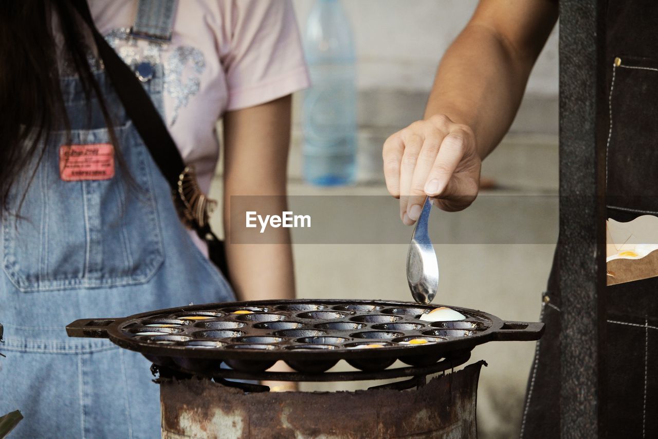 two people, adult, food and drink, midsection, food, women, person, kitchen utensil, standing, holding, apron, indoors, female, clothing, freshness, preparing food, casual clothing, togetherness, occupation, young adult, men, lifestyles, focus on foreground, cooking, hand