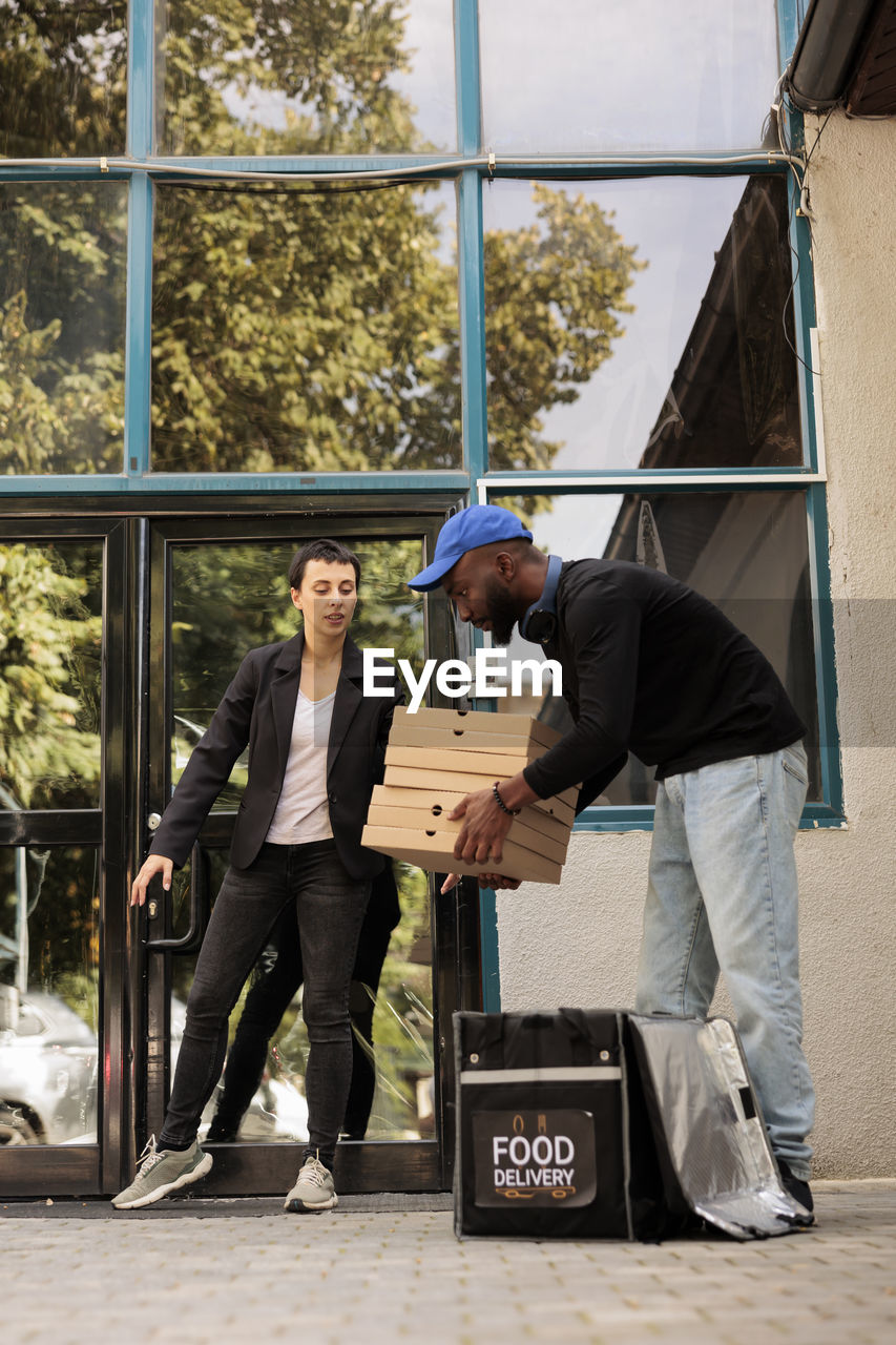 side view of man using digital tablet while standing in city