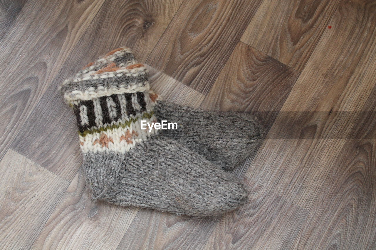 wood, art, indoors, high angle view, knitting, flooring, hardwood floor, brown, pattern, textile, footwear, still life, table, fashion accessory, wool