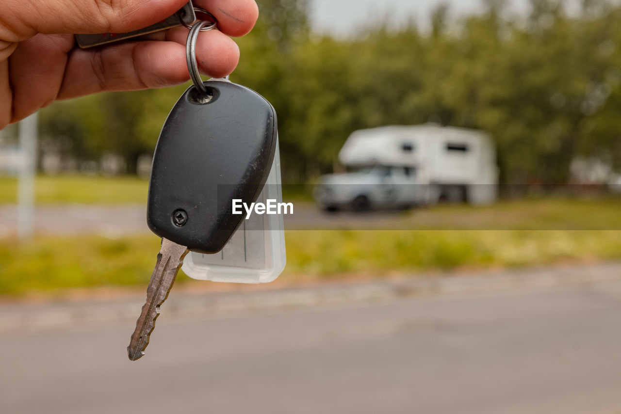 cropped hand of man holding key