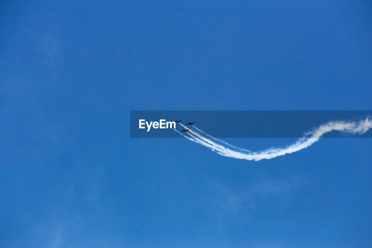 Low angle view of airplane flying in sky airshow