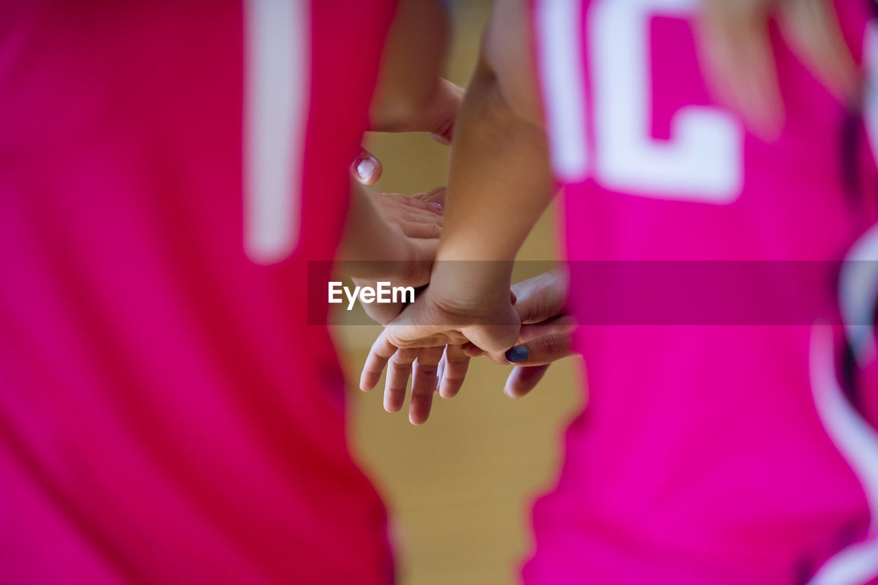 Cropped image of friends stacking hands