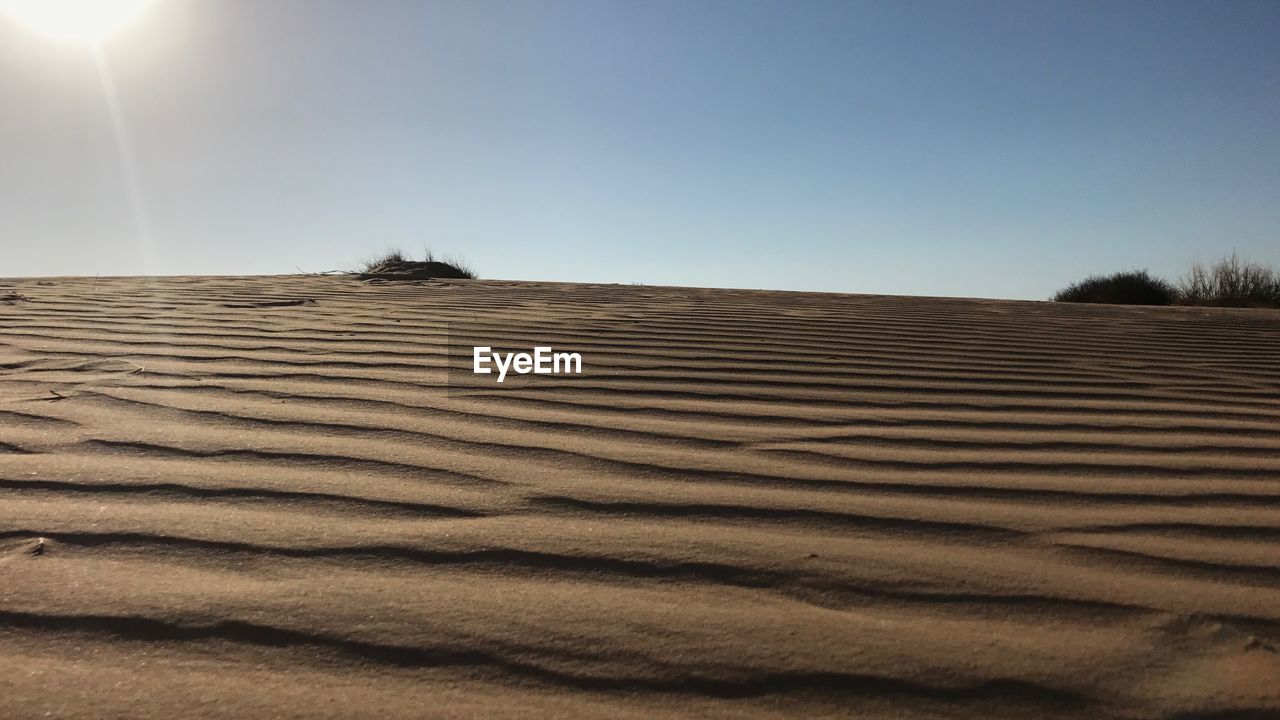 VIEW OF SAND DUNES AGAINST CLEAR SKY