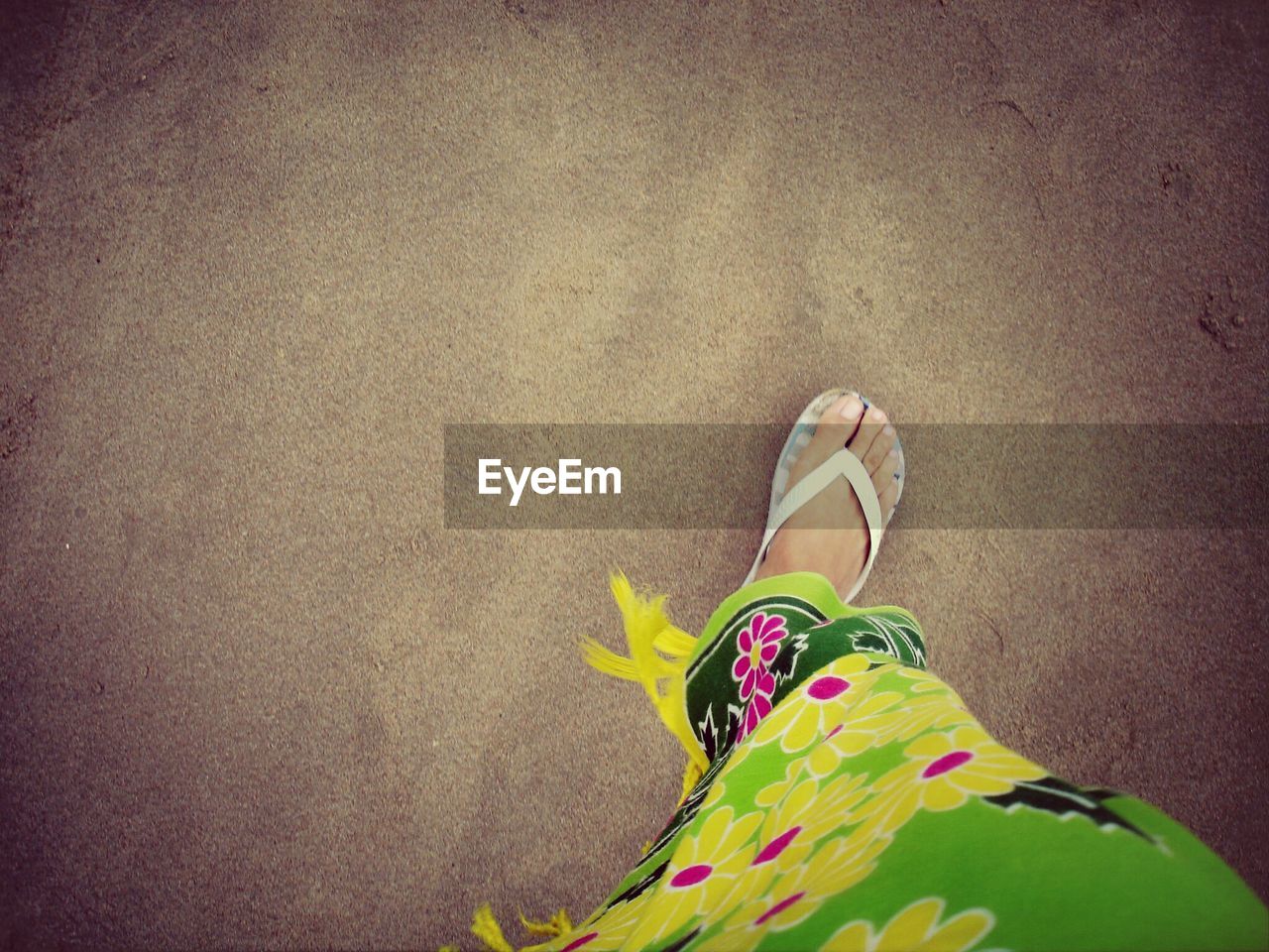 Low section of woman standing at beach