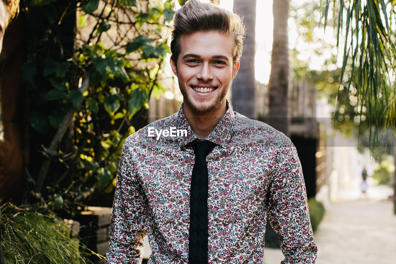 Portrait of smiling man in formalwear standing outdoors