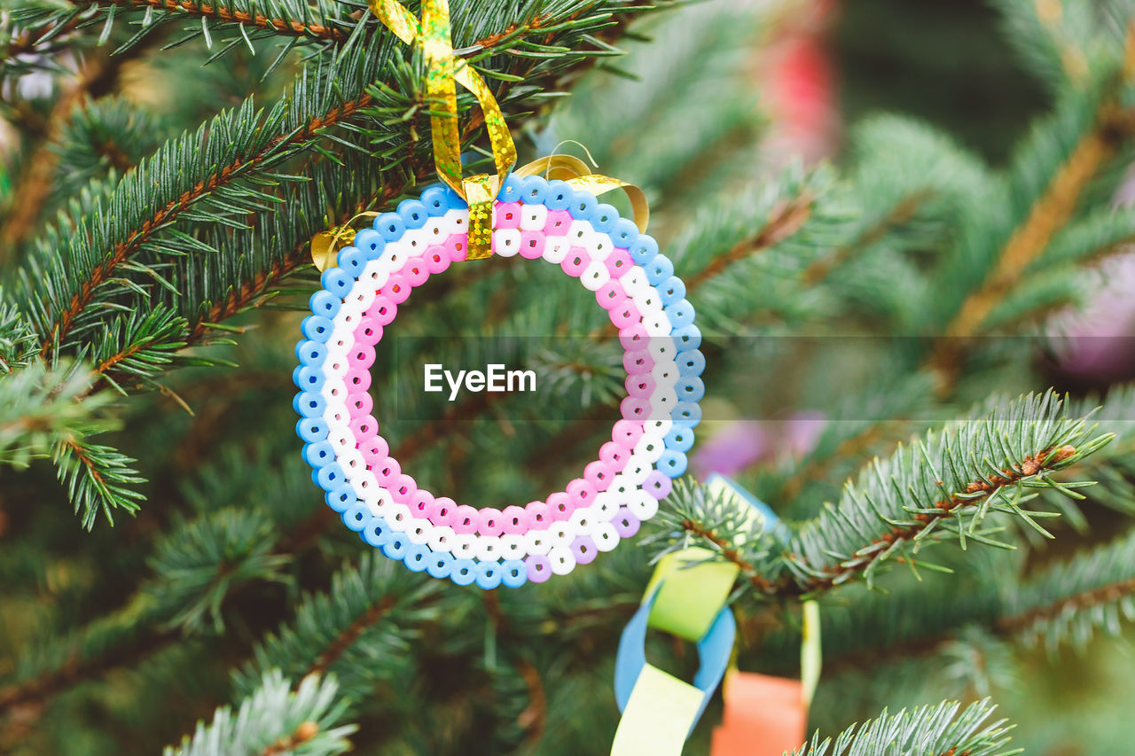 Handmade plastic beads corcle decoration on christmas tree. diy ideas for children