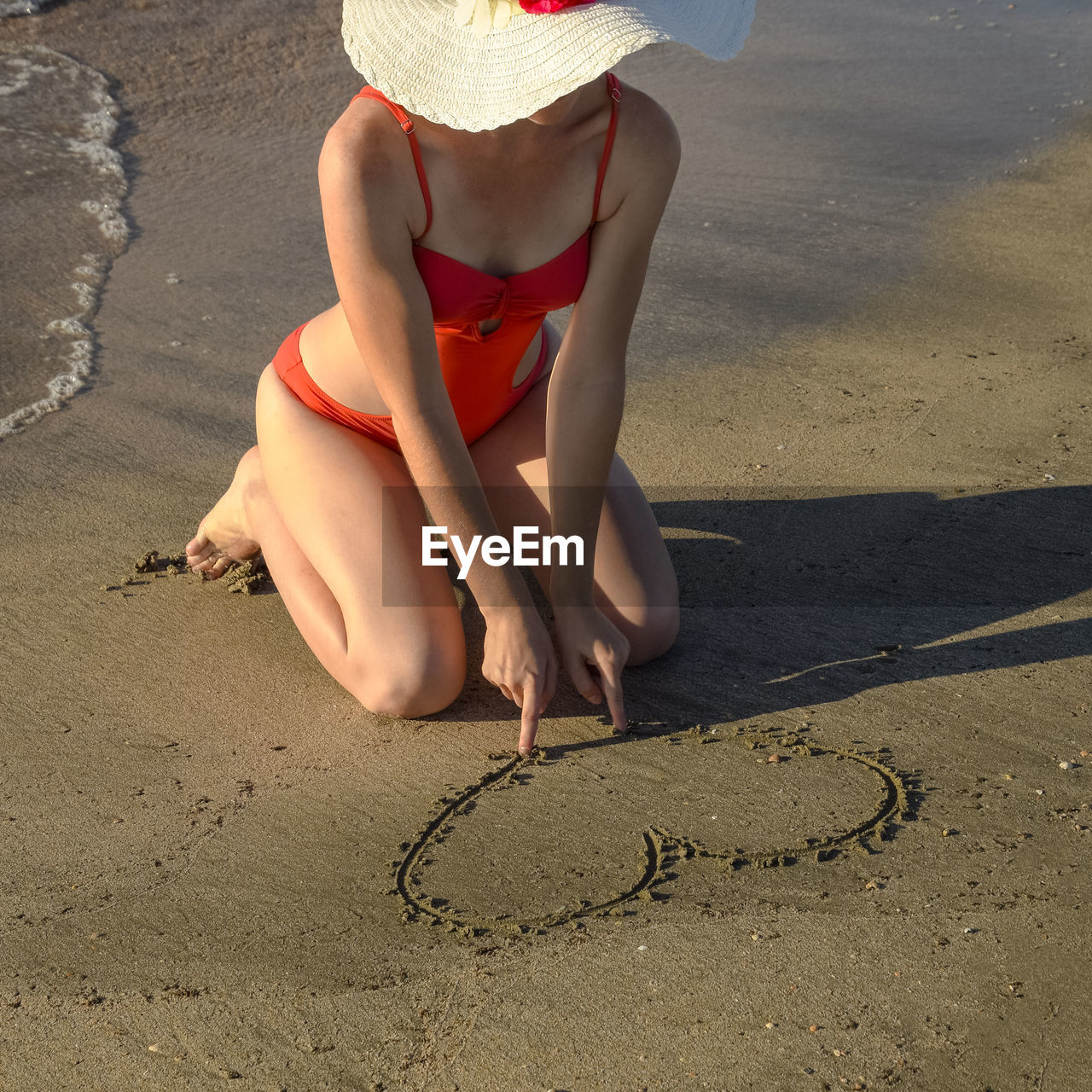 LOW SECTION OF WOMAN ON BEACH