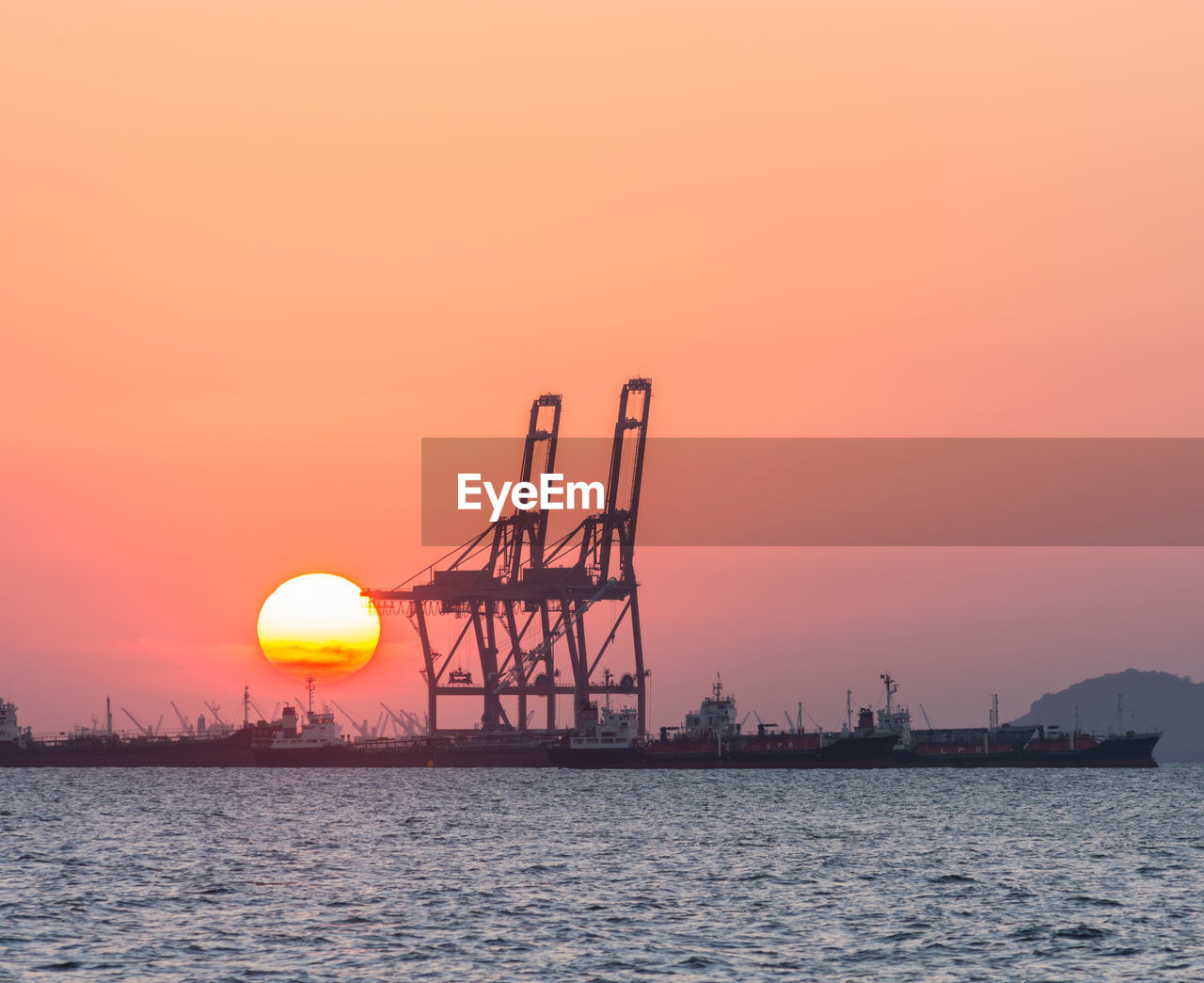 SILHOUETTE CRANE AGAINST SKY AT SUNSET