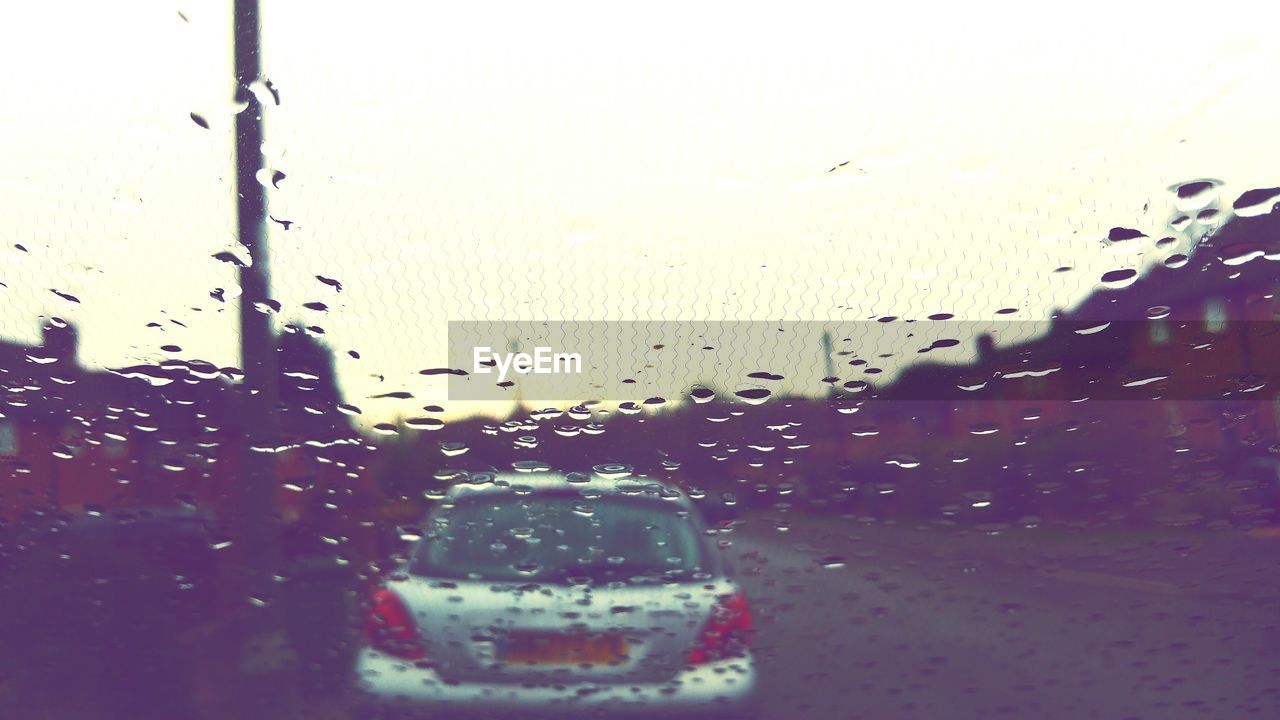 Car seen through wet window in rainy season