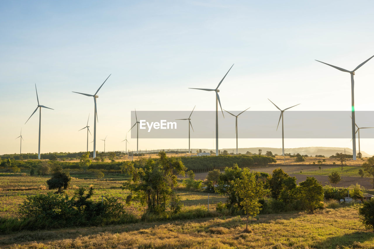 WIND TURBINES ON LAND AGAINST SKY