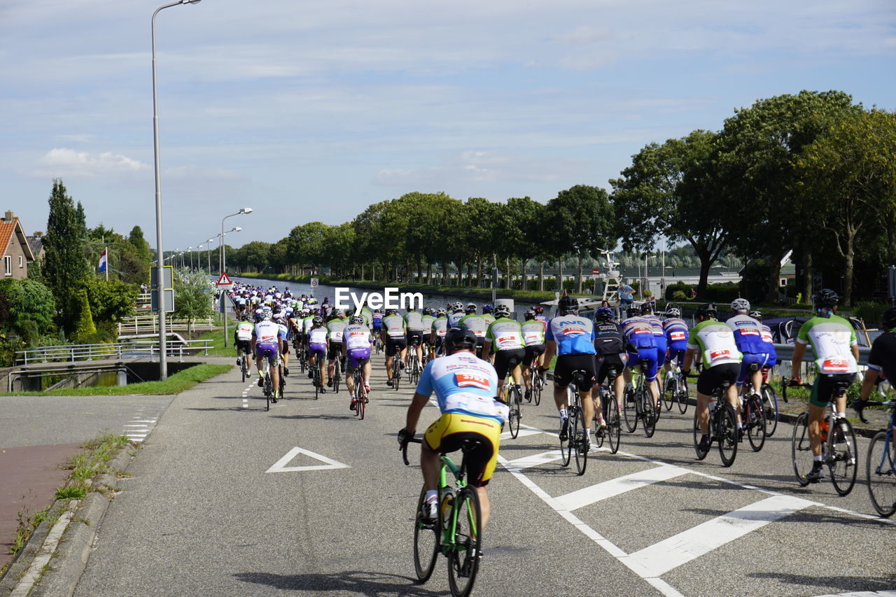 GROUP OF PEOPLE BICYCLING ON ROAD