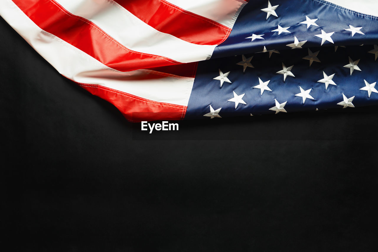 LOW ANGLE VIEW OF FLAG OVER BLACK BACKGROUND