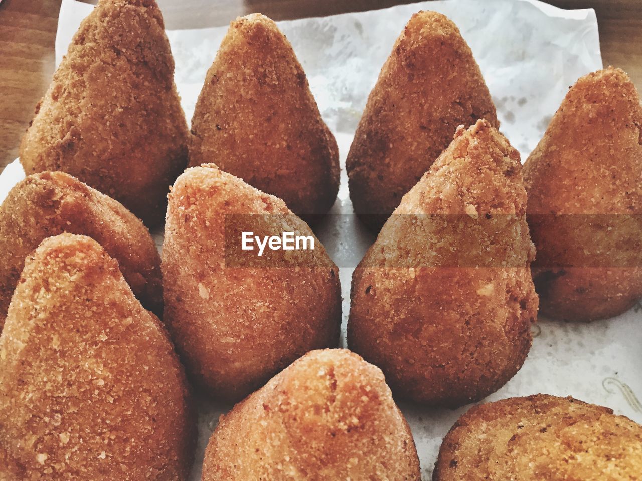 Close-up of fresh cooked arancinis on wax paper