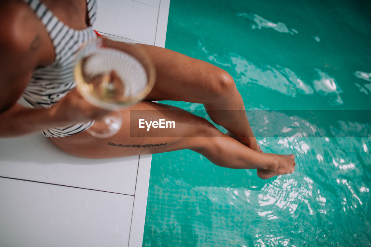 Midsection of woman swimming in pool