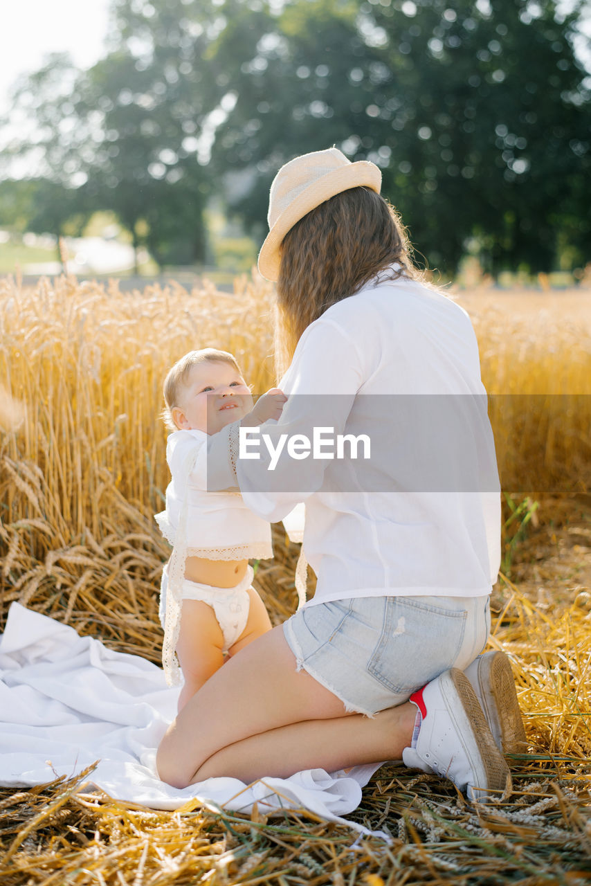 Mom changes the child's clothes on vacation in nature