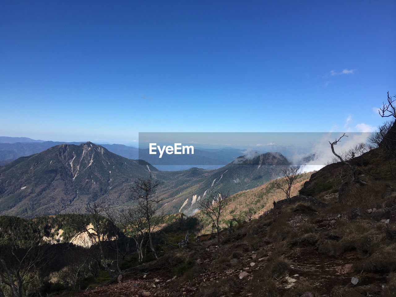 Scenic view of mountains against clear blue sky