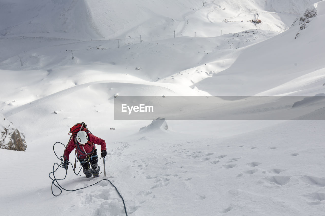 Man climbing on snow covered mountain