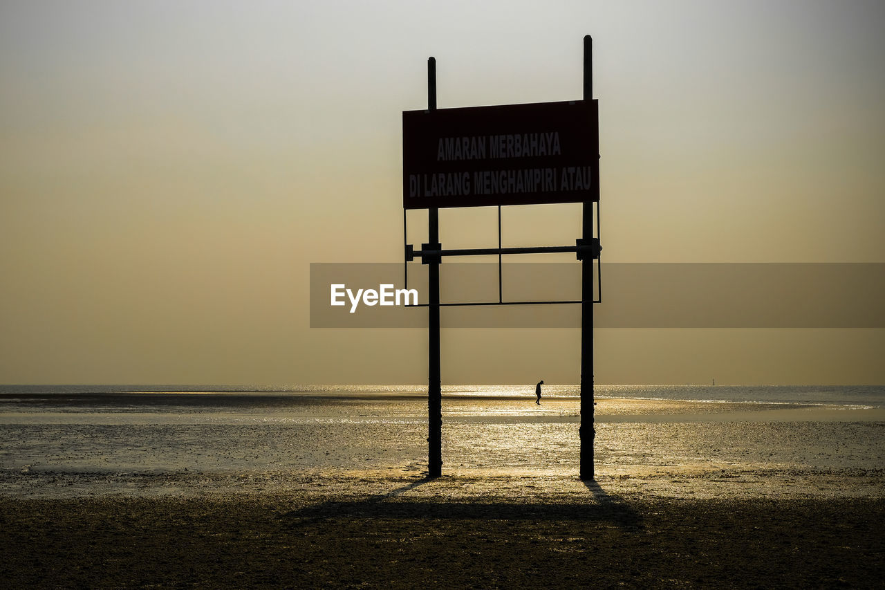 INFORMATION SIGN AT BEACH AGAINST SKY