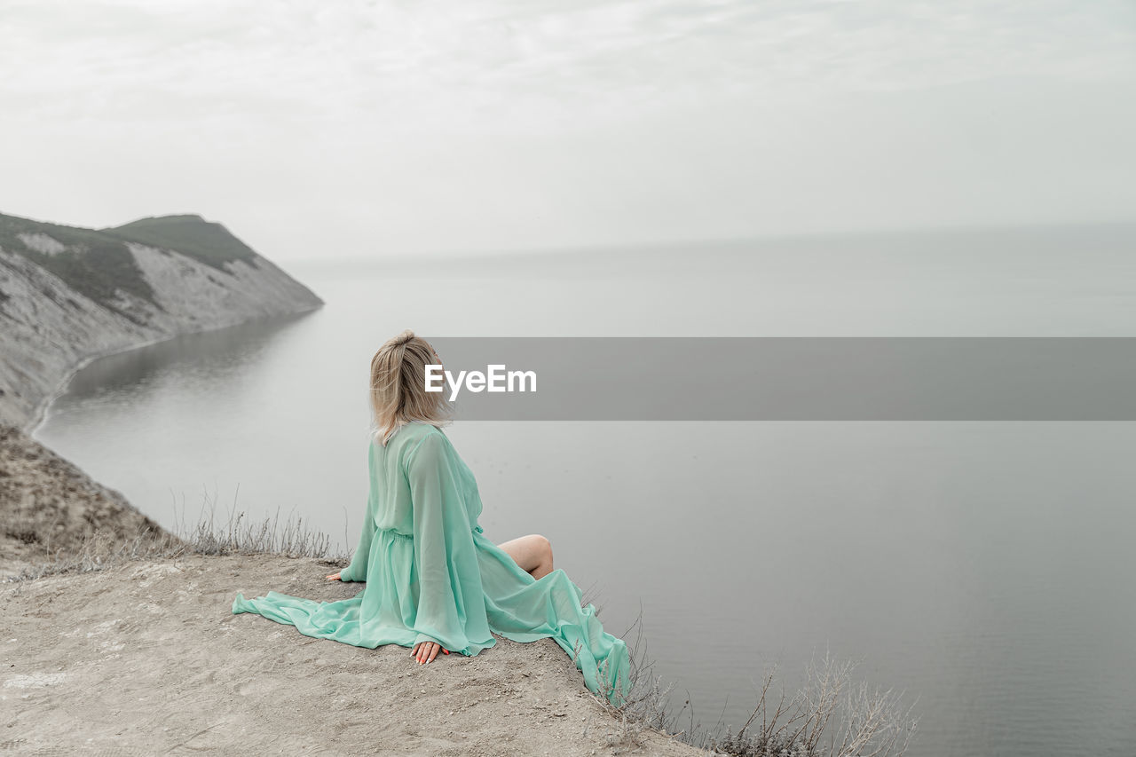 Rear view of woman looking at sea against sky