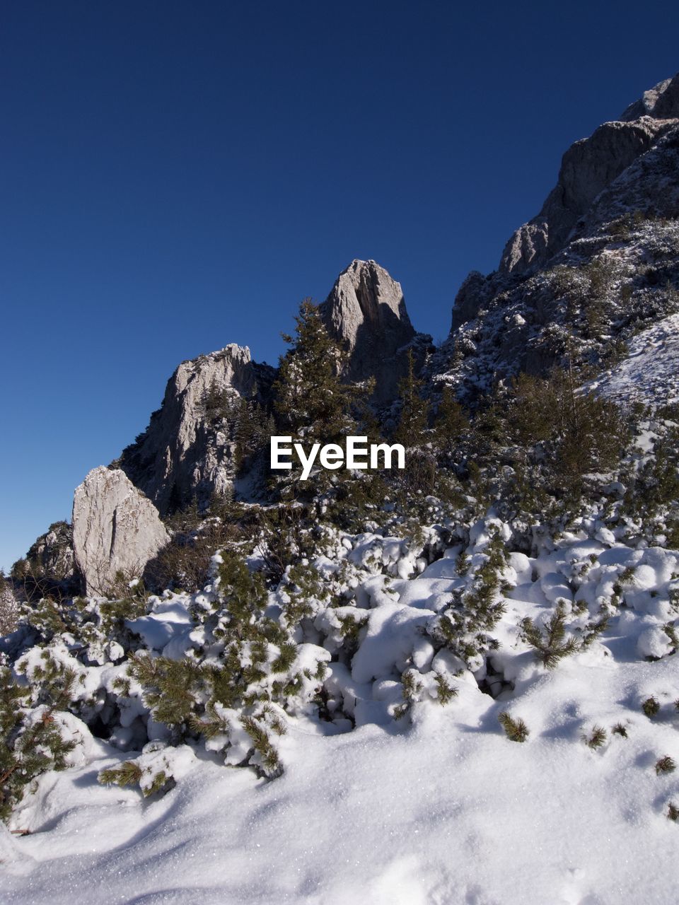 Scenic view of snowcapped mountains against clear blue sky