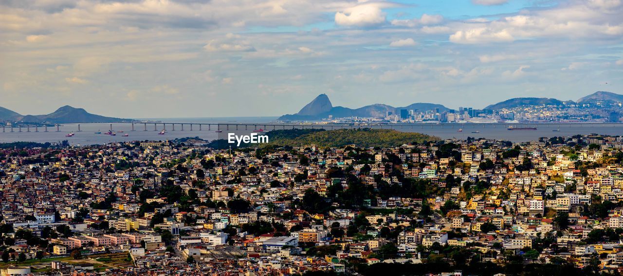 architecture, sky, mountain, city, horizon, building exterior, nature, travel destinations, cityscape, cloud, sea, land, built structure, building, crowd, water, scenics - nature, landscape, travel, coast, outdoors, environment, beauty in nature, crowded, tourism, mountain range, town, high angle view, beach, evening, skyline, dusk, panoramic, aerial photography, residential district