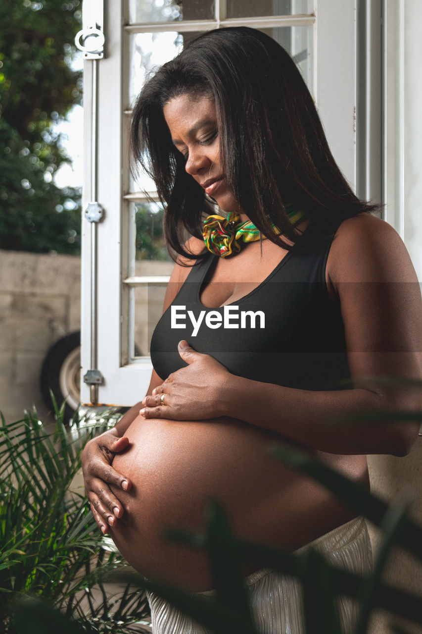 Side view of pregnant woman standing outdoors