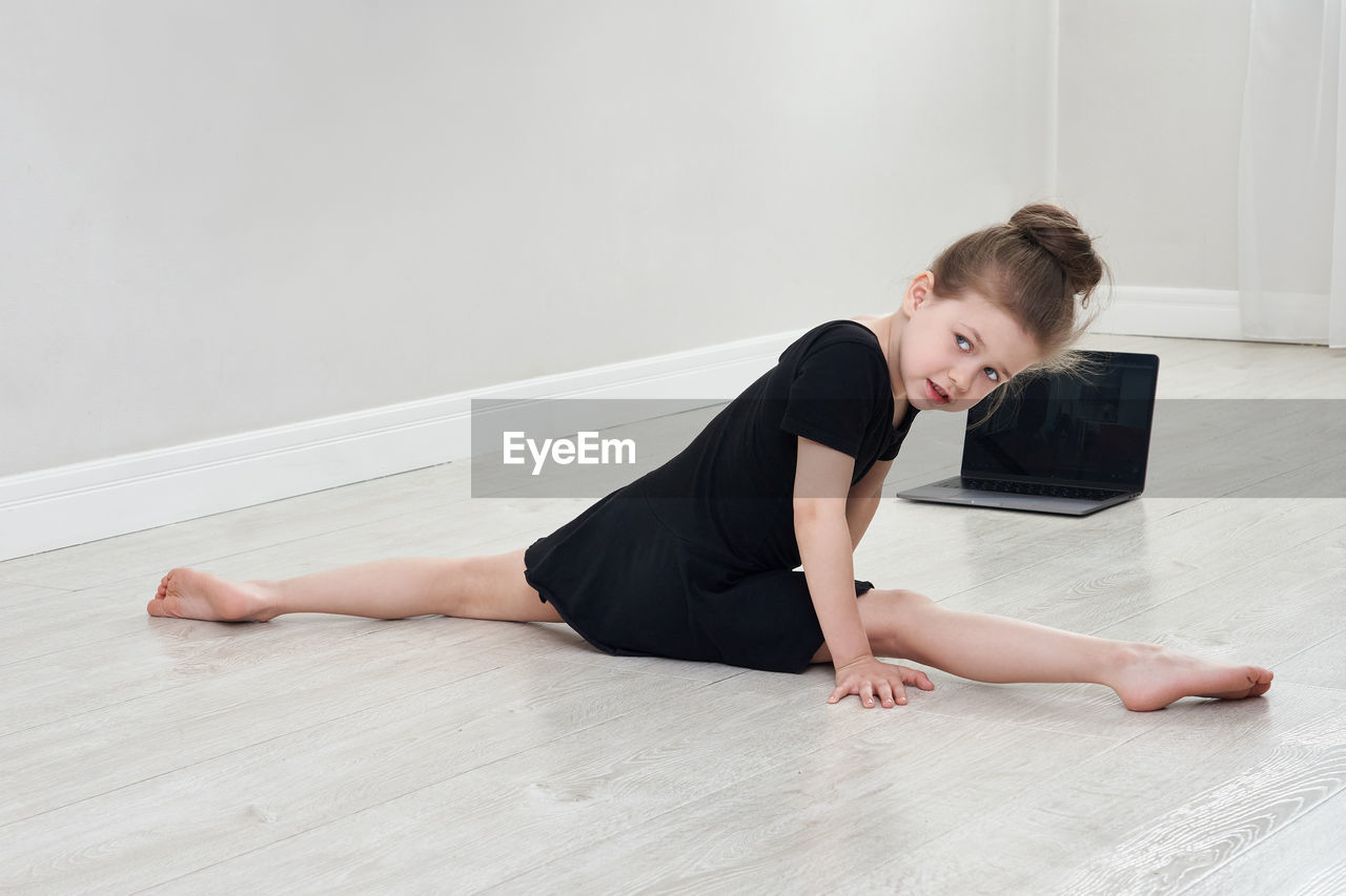 Girl looking away while doing split at home