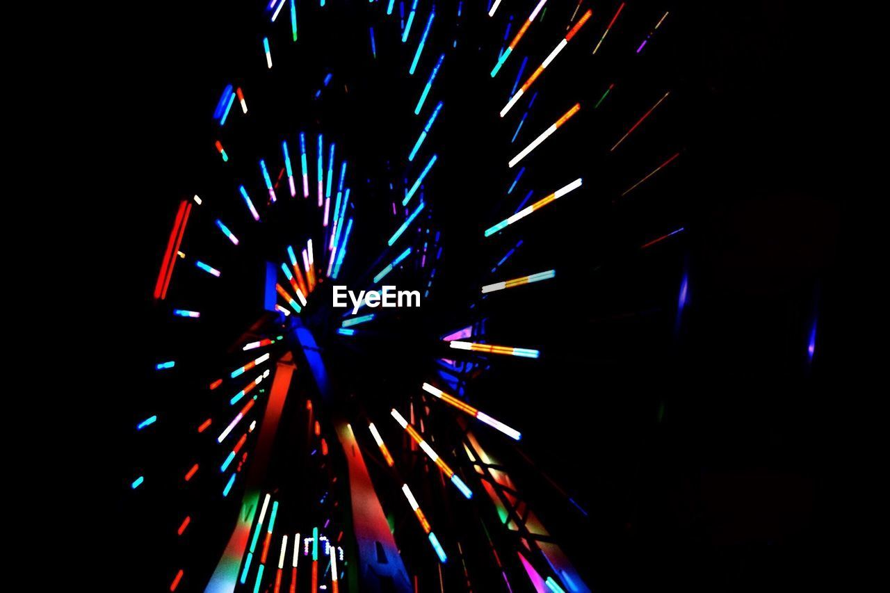 Low angle view of illuminated lights on ferris wheel at night