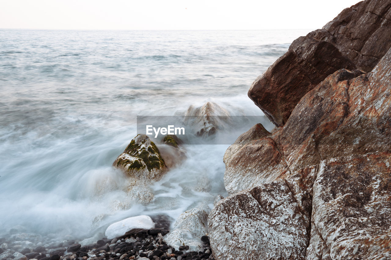 ROCKS IN SEA AGAINST SKY