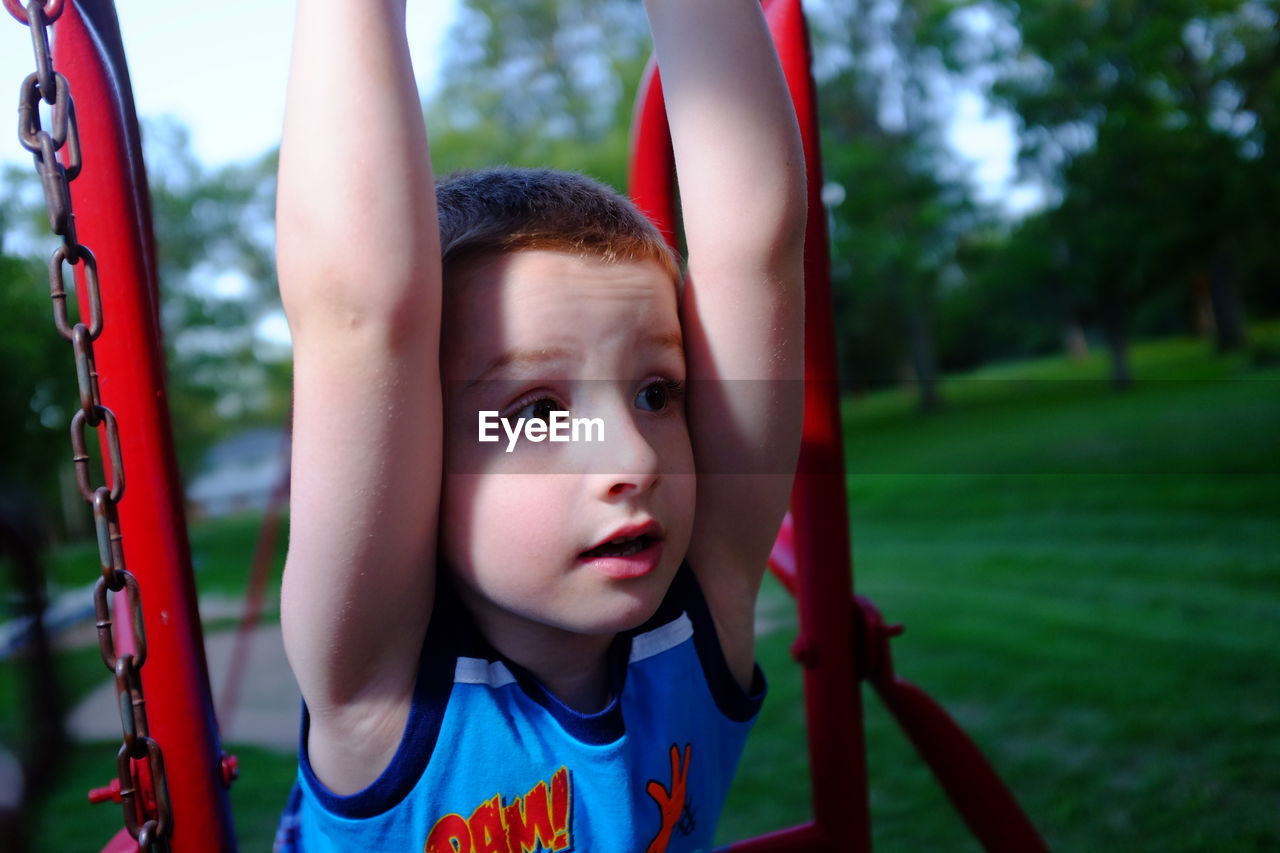 Close-up of cute boy playing on ride in park