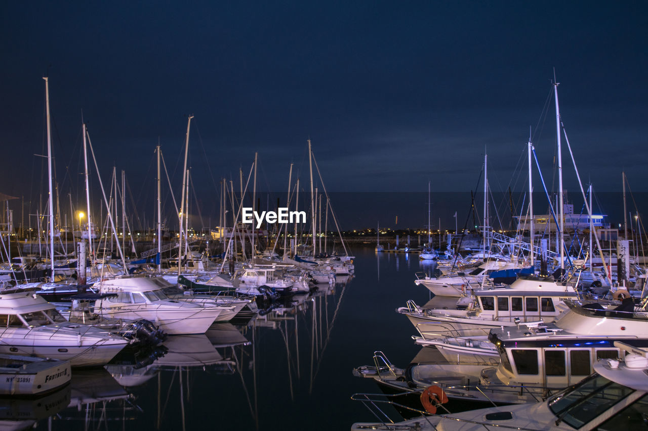 SAILBOATS MOORED IN HARBOR