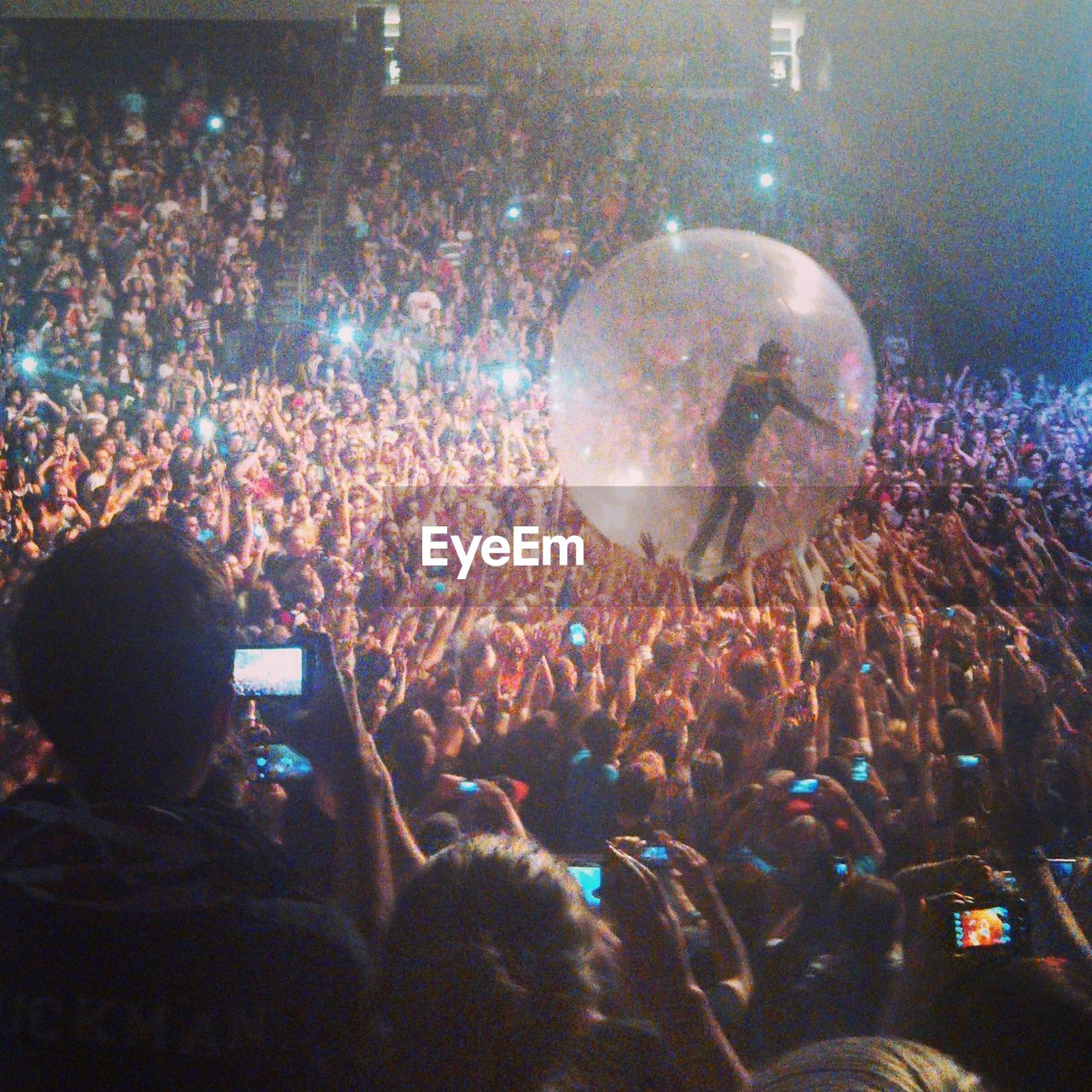 REAR VIEW OF PEOPLE ENJOYING AT MUSIC CONCERT