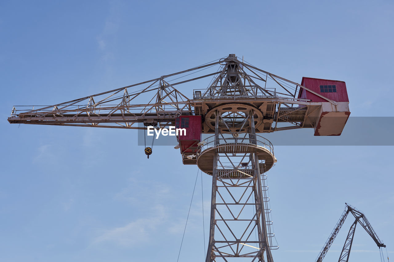 Low angle view of crane against sky